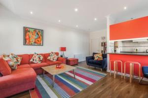 a living room with a red couch and a table at Blackfriars Cosy Retreat in Glasgow