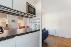 a kitchen with a counter top and a living room at Blackfriars Cosy Retreat in Glasgow +2 photos