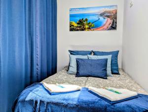 a bedroom with blue curtains and a bed with towels on it at Ocean View Apartments in Adeje +45 photos