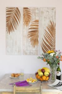 a table with a bowl of fruit and a vase of flowers at Stunning Ocean & Mountain View Apartment in Glencairn
