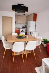 a dining room with a wooden table and white chairs at One-Bedroom flat Meden Rudnik zone B in Burgas
