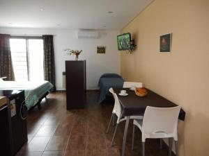 a living room with a table and a bedroom at Mariaflorales in San Rafael