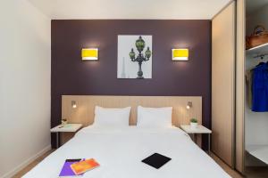 - une chambre avec un grand lit et 2 tables dans l'établissement Aparthotel Adagio Access Paris Clichy, à Clichy