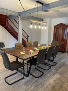 a dining room with a large wooden table and chairs at DenkMal Auszeit in Waibstadt