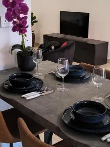 a table with black plates and wine glasses on it at Eva Luxury Apartment in Paphos