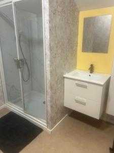 a white bathroom with a shower and a sink at Au Petit Bouchon in Le Breuil