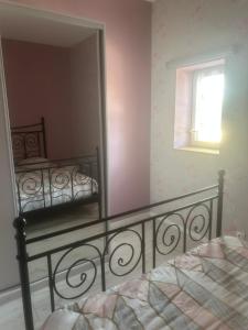 a bedroom with a mirror and a bed and a window at Au Petit Bouchon in Le Breuil