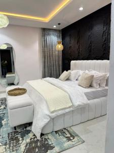 a bedroom with a large white bed and a mirror at Paradise View Villas in Malindi +4 photos