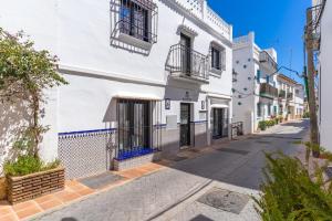 a street with white buildings and a sidewalk at Los Naranjos House in Marbella