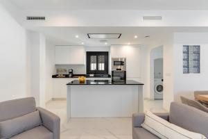 a kitchen and living room with couches and a counter at Los Naranjos House in Marbella