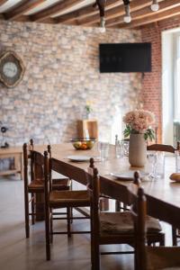 a wooden table with chairs and a television on a brick wall at Bienvenue chez Pépère in Nitry