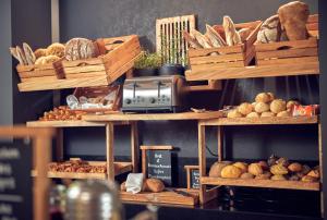 Un estante lleno de diferentes tipos de pan y otros alimentos. en Wasserturm Hotel Cologne, Curio Collection by Hilton, en Colonia