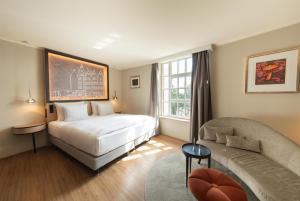 una habitación de hotel con cama y sofá en Wasserturm Hotel Cologne, Curio Collection by Hilton, en Colonia