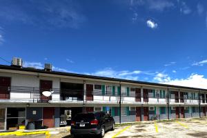 a car parked in a parking lot in front of a building at Briarwood Motel Near Valdosta University I 75 in Valdosta