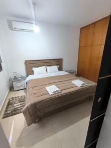 a bedroom with a large bed with two towels on it at Eva Luxury Apartment in Paphos