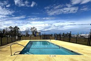 a swimming pool with a fence and a blue sky at Briarwood Motel Near Valdosta University I 75 in Valdosta