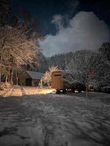 a snow covered yard with a cabin and trees at Auszeit in stilvollem Tiny House in Elsdorf +2 photos