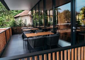 a patio with tables and chairs on a balcony at NOVO Studio Hotel in Râmnicu Vâlcea