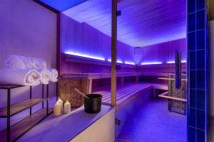 una habitación morada con bañera y toallas en Wasserturm Hotel Cologne, Curio Collection by Hilton, en Colonia