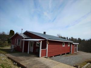 a red house with a porch and a deck at Familjenest in Bollnäs