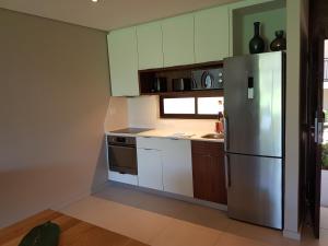 a kitchen with a stainless steel refrigerator and white cabinets at Zimbali Suites 110 in Ballito