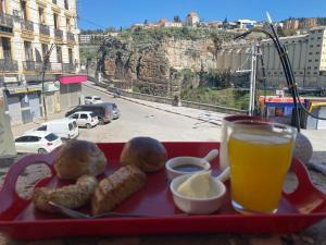 a tray of food and a glass of beer and some food at Hostel le Rhumel in Constantine