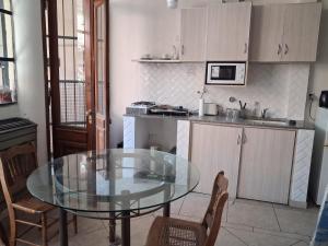 a kitchen with a glass table in a kitchen at Loft Junín in Junín +3 photos
