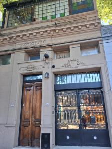 a building with two wooden doors and windows at Loft Junín in Junín