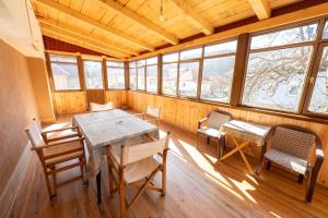 a dining room with a table and chairs and windows at Apartmani Dino Kolasin in Kolašin