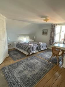 a bedroom with two beds and a table in it at Brunnsta Gård in Bålsta +86 photos
