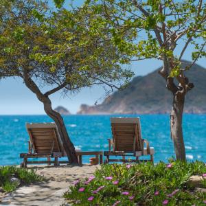 dos sillas sentadas en la playa cerca del agua en Yonca Lodge, en Fethiye