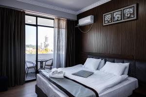 a bedroom with a bed with two towels on it at Hotel Red Tower in Zugdidi