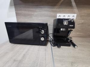a black toaster oven sitting on top of a counter at River Apartman 2 in Odorheiu Secuiesc +14 photos