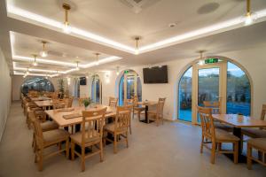 a restaurant with tables and chairs and a flat screen tv at Pensiunea Bila in Naipu