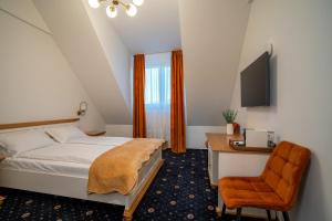 a bedroom with a bed and a desk and a chair at Pensiunea Bila in Naipu