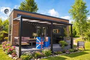 a small black shed with a table in a garden at Romantisches Tiny House direkt am See, Ruhe & Natur in Salzhemmendorf
