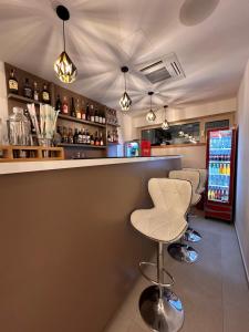 a bar with a row of stools and a counter at Pensiunea Bila in Naipu