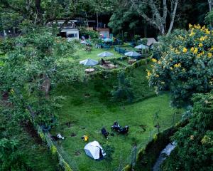 a group of people sitting in a field with tents at Njukiini Forest Lodge in Embu
