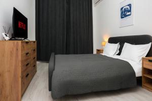a bedroom with a bed and a dresser with a television at Escape Studio 4 Pollux Militari in Chiajna