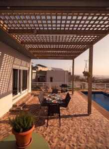 a patio with a table and chairs under a pergola at Klima Breeze in Klíma