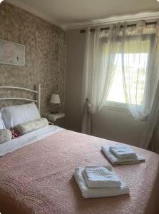 a bedroom with a bed with two towels on it at Άνεμος Home in Elaiokhórion