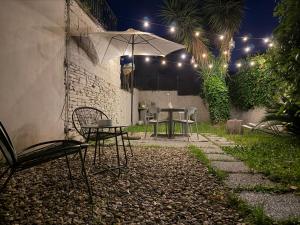 a patio with a table and chairs and an umbrella at Dimora Costanza in Lucca