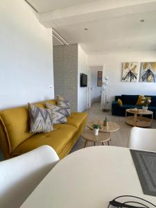 a living room with a yellow couch in a living room at Estrella de Martil in Martil