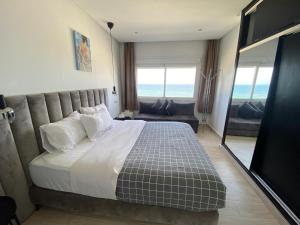 a bedroom with a large bed and a view of the ocean at Estrella de Martil in Martil