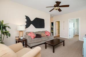 a living room with a couch and a ceiling fan at This Is It by Oak Island Accommodations in Oak Island