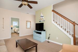 a living room with a ceiling fan and a tv at This Is It by Oak Island Accommodations in Oak Island