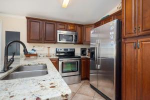 a kitchen with stainless steel appliances and wooden cabinets at This Is It by Oak Island Accommodations in Oak Island