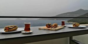 a table with plates of food and beers on a ledge at Grand süit in Kalkan