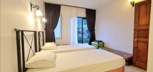 two beds in a room with a window at Grand süit in Kalkan