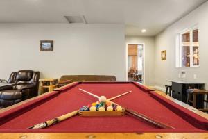 a pool table with balls and bats on top of it at Rare Indoor Pool, Game Room & Courts, 5 Blocks to Snow Summit in Big Bear Lake